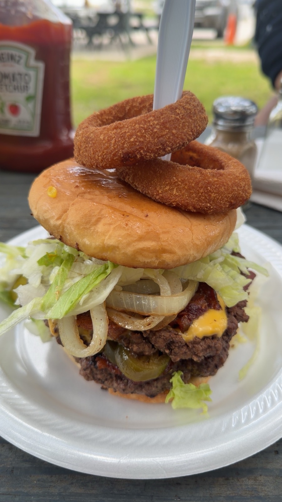 Ringer Burger topped with a crispy onion ring on a pick