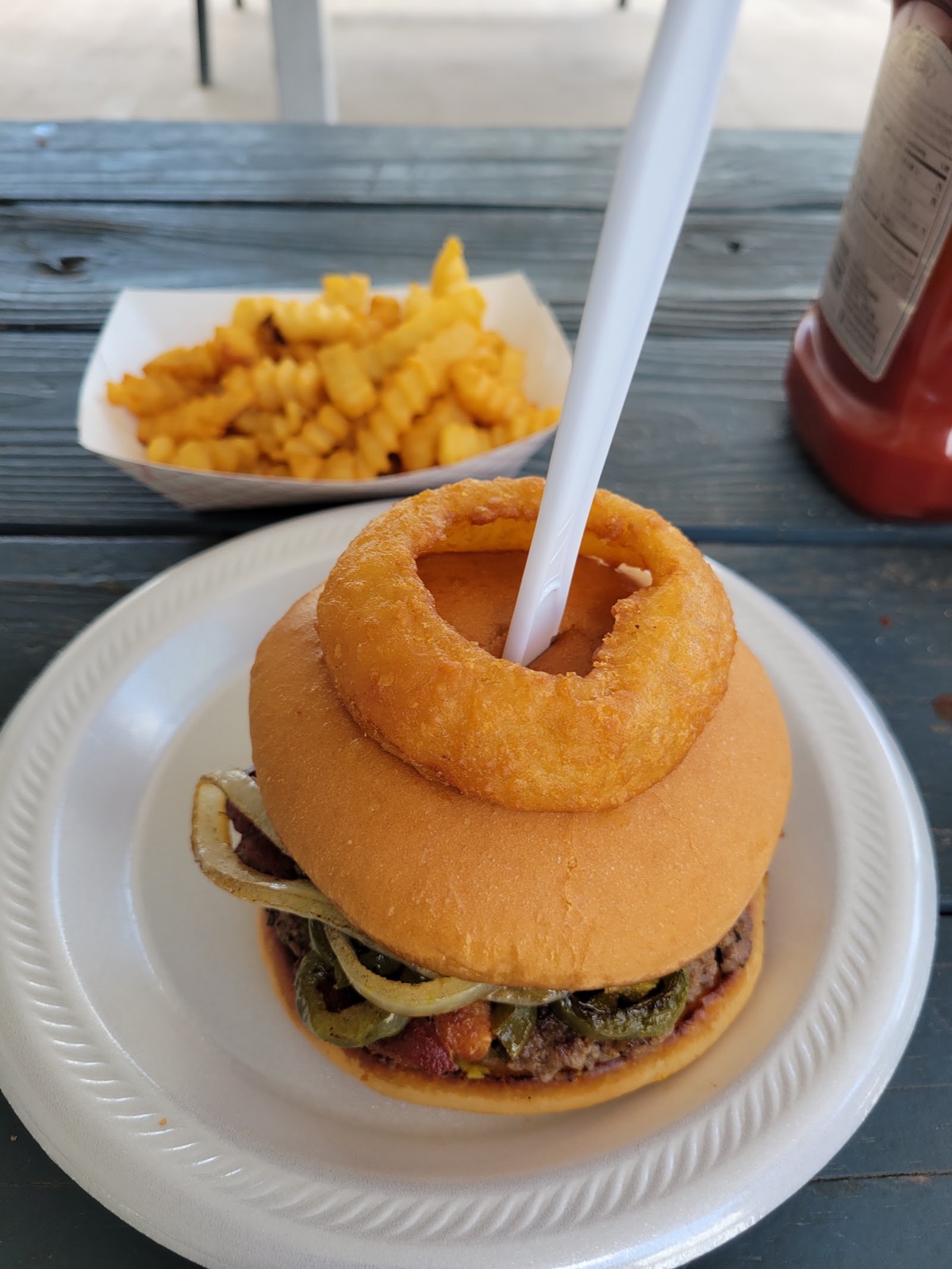 Ringer Burger with onion ring, served with golden fries